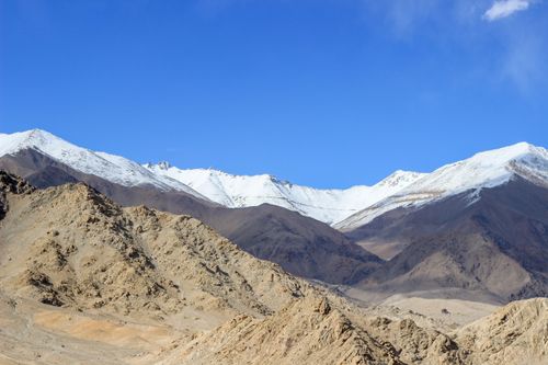 Free Majestic snow-capped mountains in Ladakh, India, under a clear blue sky. Perfect for travel and nature enthusiasts. Stock Photo