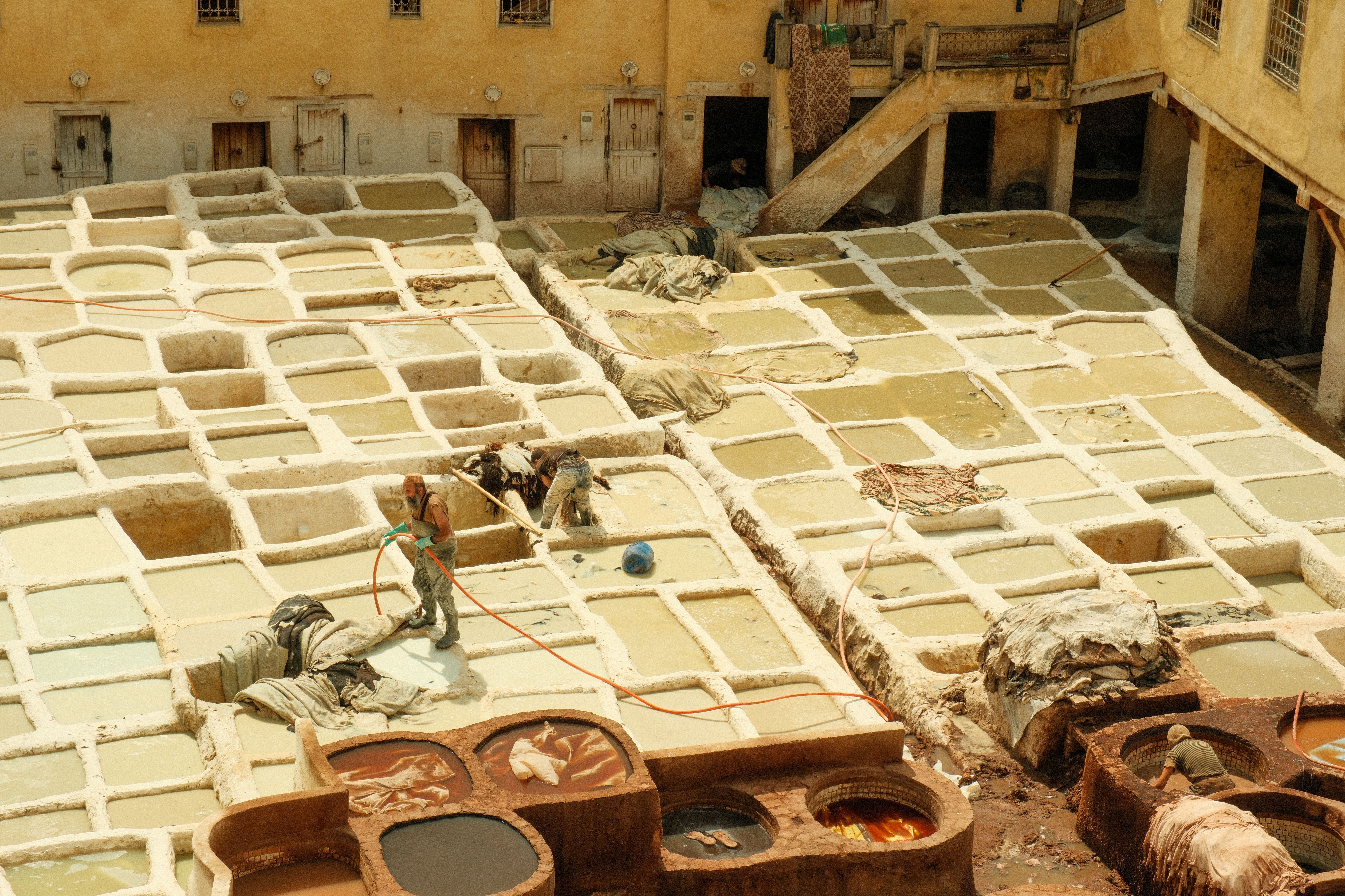 Aerial view of a traditional leather tannery in Fes, Morocco, showcasing workers at the site.
