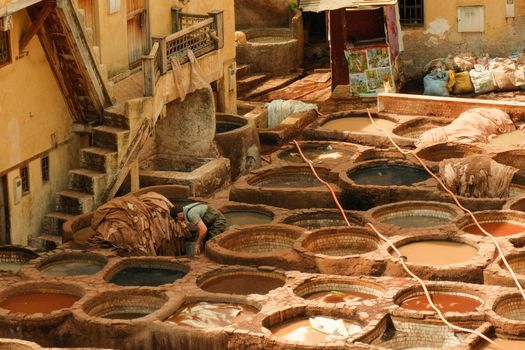 Aerial view of traditional tannery vats in Fes, Morocco, capturing ancient leather dyeing techniques.