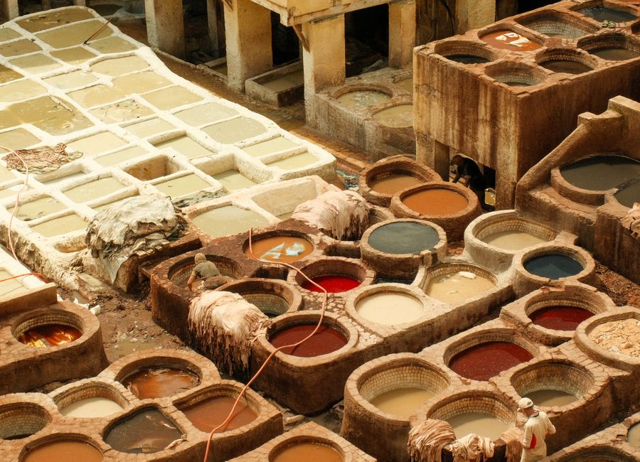A vibrant aerial view of the traditional tanneries in Fes, Morocco, showcasing the dyeing process.