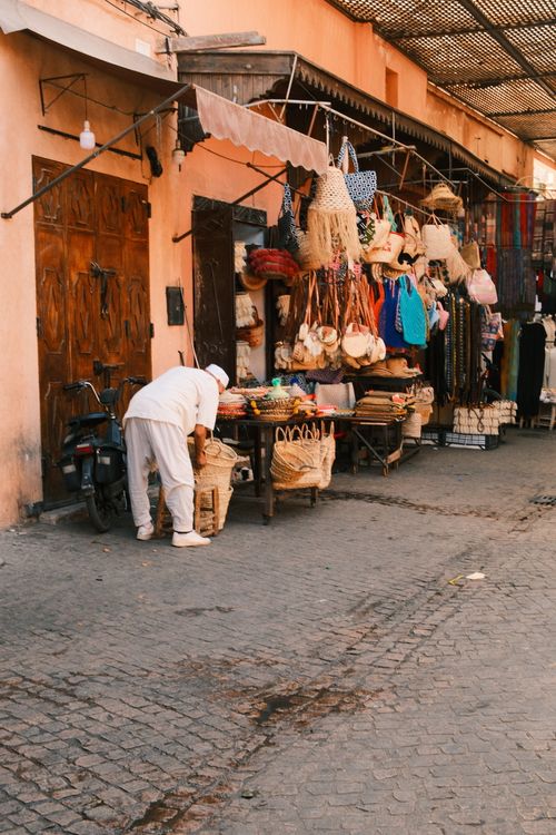 Free A vibrant street market in Marrakesh selling traditional Moroccan goods under warm daylight. Stock Photo