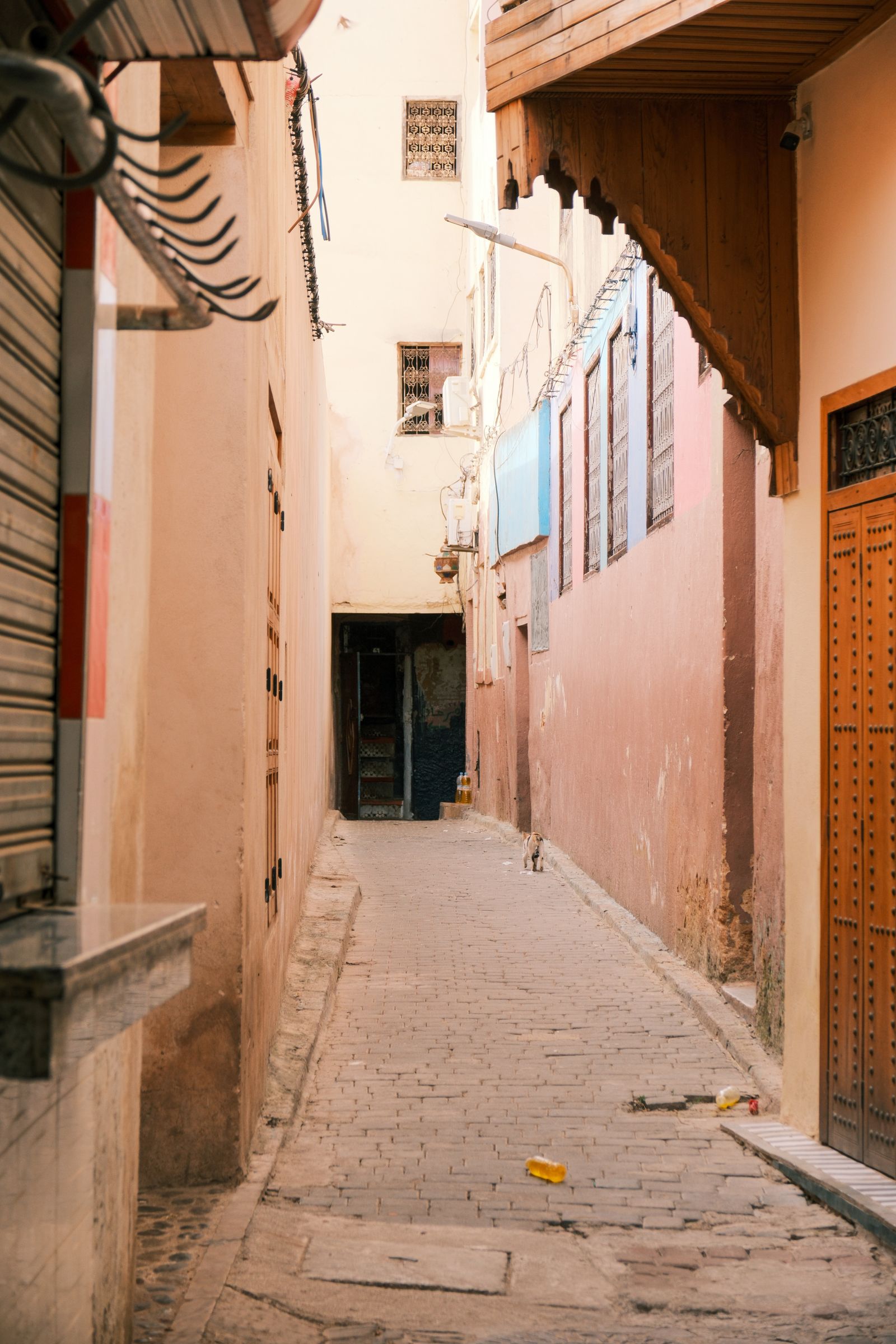 Narrow street in Fes Medina with traditional architecture, showcasing historical charm.