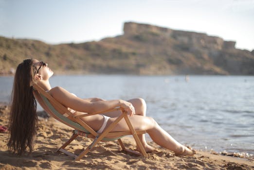 一名女子穿着比基尼，在海边的沙滩上晒着日光浴，享受夏日宁静