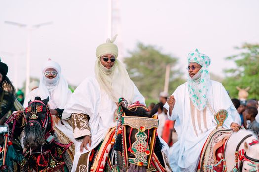 Vibrant display of cultural heritage with horsemen in traditional attire during a ceremonial parade.