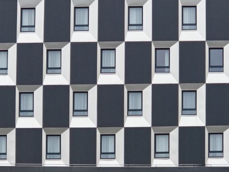 Facade of a modern building with a repetitive geometric window pattern.