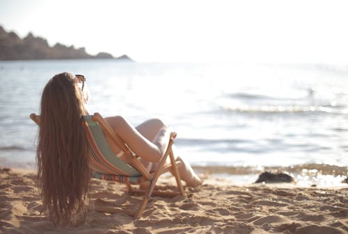 Vrouw In Witte Bikini Liggend In Strandstoel