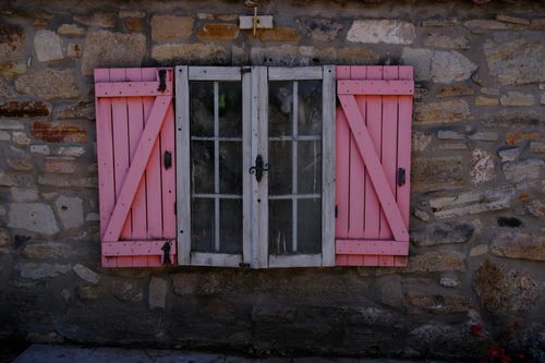 Free Charming rustic window with pink shutters on a stone wall in Foça, İzmir, Türkiye, showcasing vibrant and classic architecture. Stock Photo