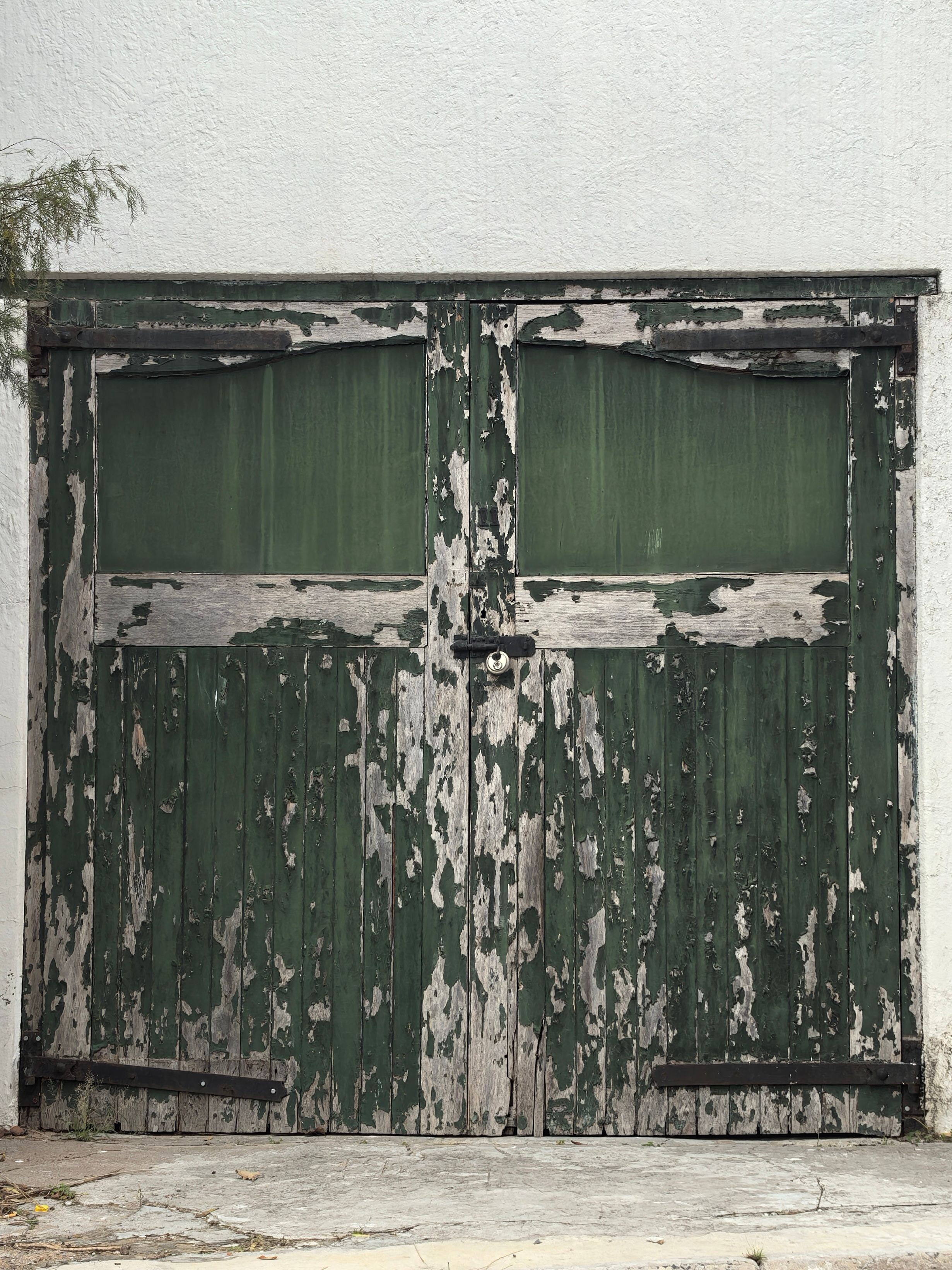 A rustic, weathered green door with peeling paint in Cape Town, South Africa.