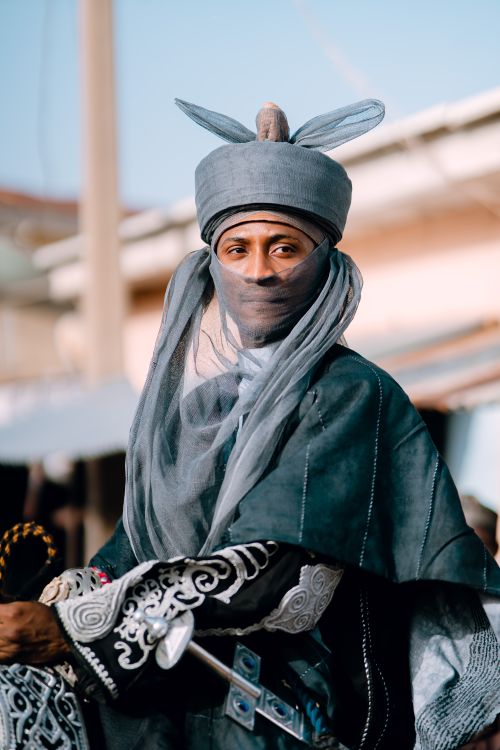 Free A man wears traditional garb with intricate designs in an outdoor setting, conveying cultural heritage. Stock Photo