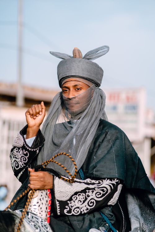 Free A man dressed in traditional attire riding a horse outdoors, showcasing cultural heritage. Stock Photo