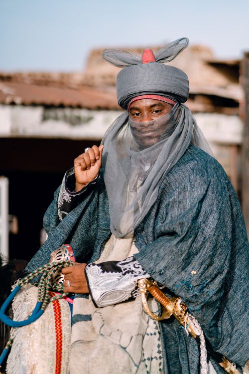 Free Portrait of a person in traditional nomadic attire with intricate fabric outdoors. Stock Photo