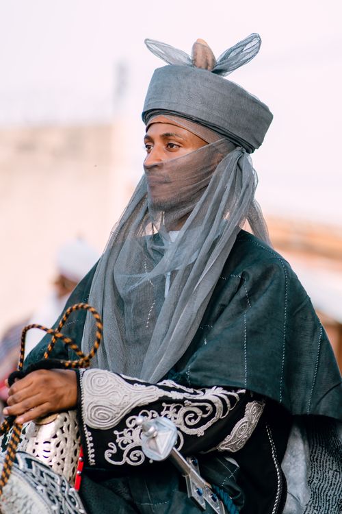 Free Man in traditional African attire with intricate patterns participating in a cultural parade. Stock Photo