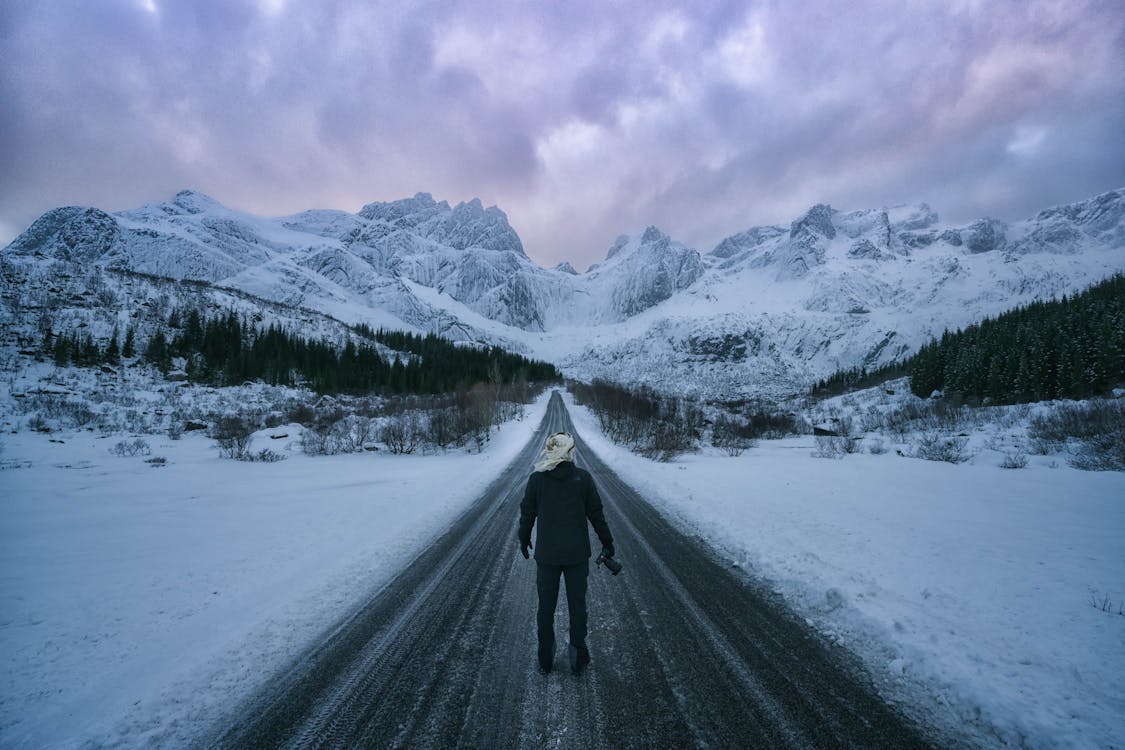 Free Person Walking on Snow Covered Road Stock Photo