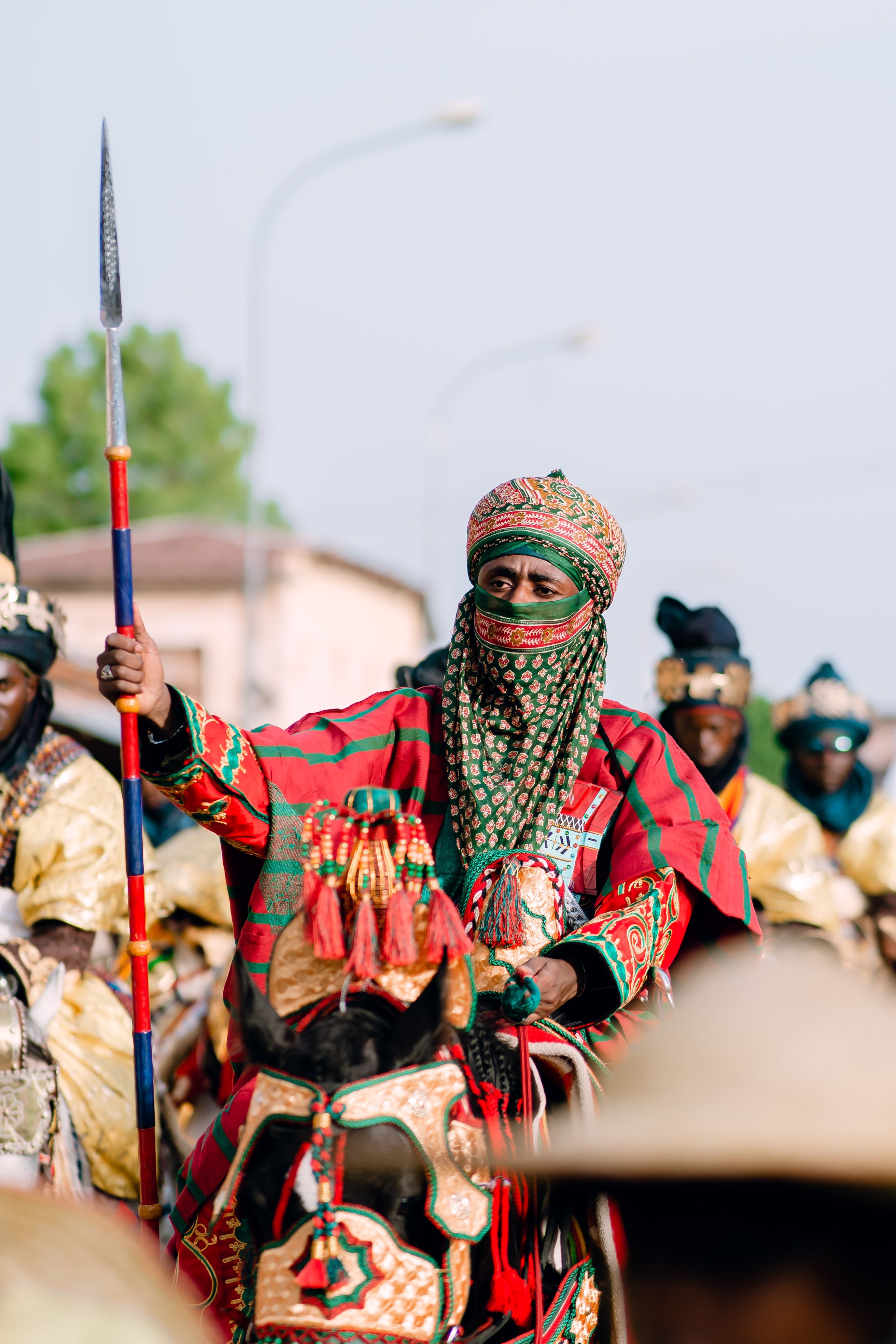 Colorful parade featuring traditionally dressed riders in vibrant attire, celebrating cultural heritage.