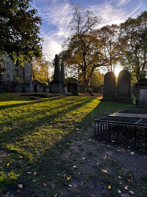 Free Sunlit Scottish graveyard with headstones and autumn trees in Edinburgh, Scotland. Stock Photo
