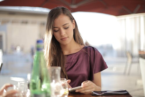 Free Wanita Baju Atasan Ungu Menggunakan Smartphone Stock Photo