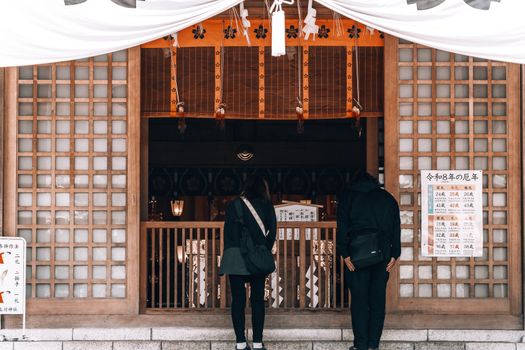 Visitors at a Japanese temple in Hokkaido, offering a glimpse into cultural practices.