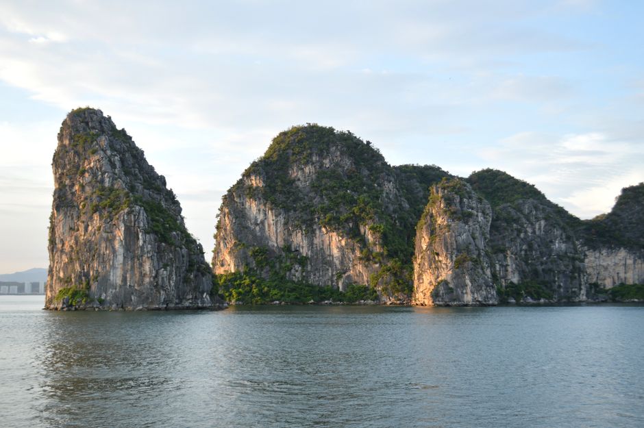 Scenic view of iconic limestone cliffs reflecting in the ocean at Halong Bay, Vietnam.
