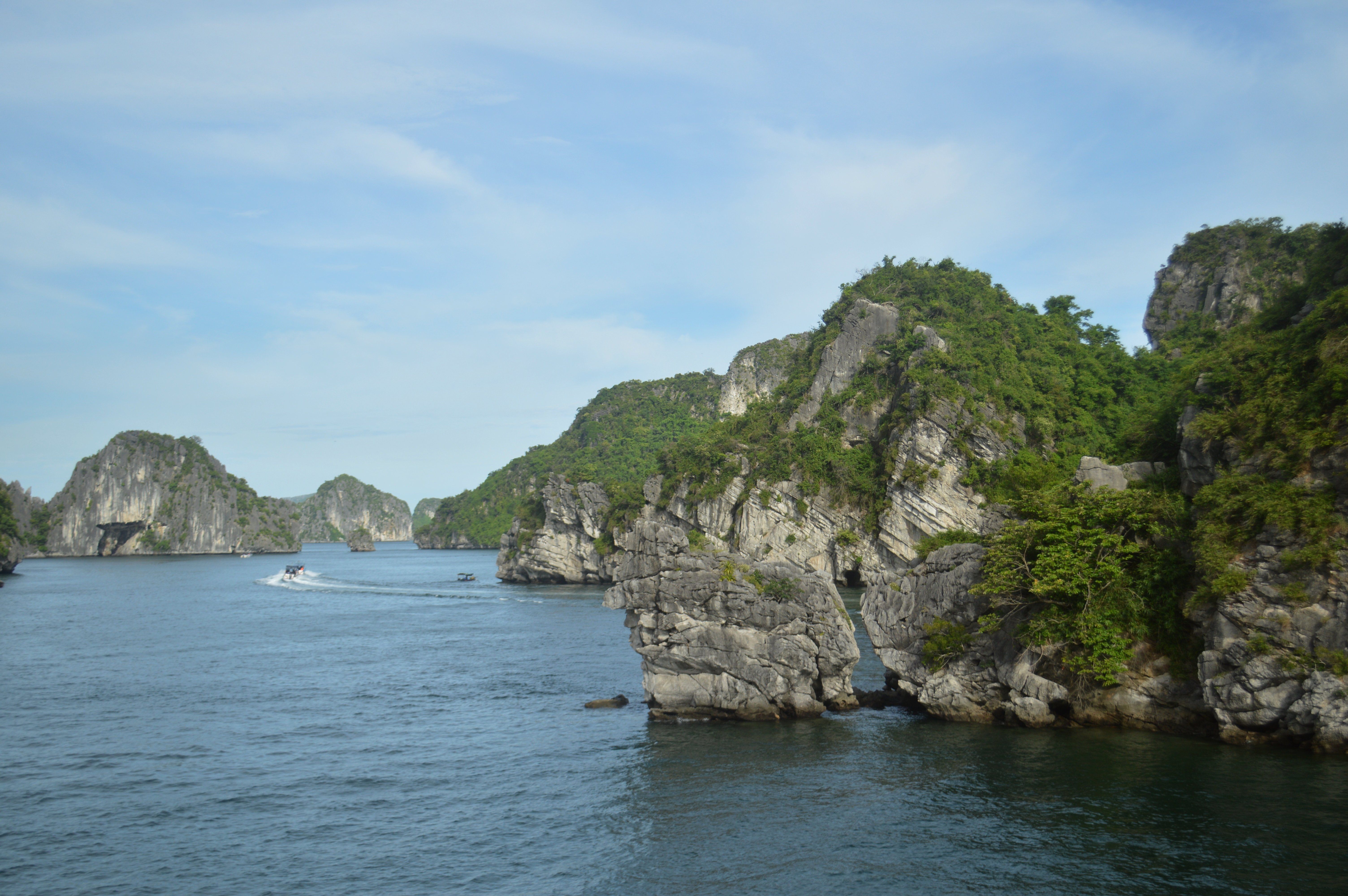 Discover the stunning limestone formations and tranquil waters of Halong Bay under a clear blue sky.