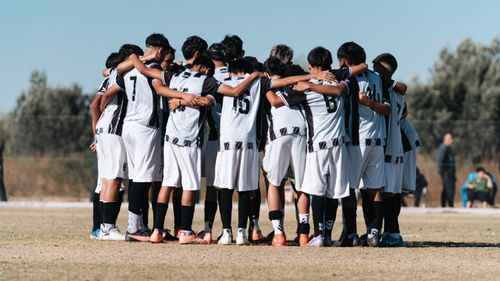 Free Youth soccer team huddling on the field, preparing for the game together. Stock Photo