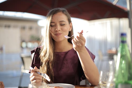 Free Woman in Purple Eating Stock Photo