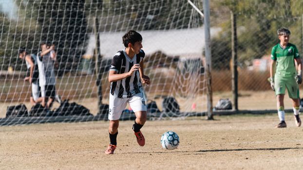 Young soccer player in action during a daytime outdoor match.