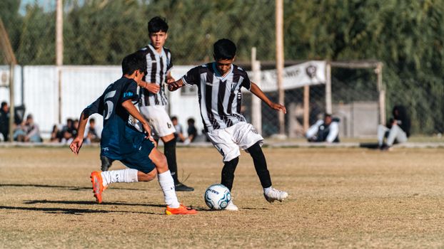 Boys playing soccer outdoors on a sunny day, showcasing youthful energy and teamwork.