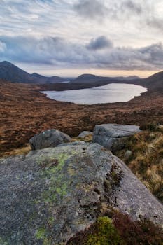 Peaceful landscape of a lough surrounded by the Mourne Mountains at dusk.