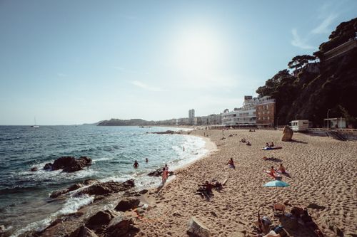 Free Scenic view of Lloret de Mar beach with people enjoying the sun and sea. Stock Photo