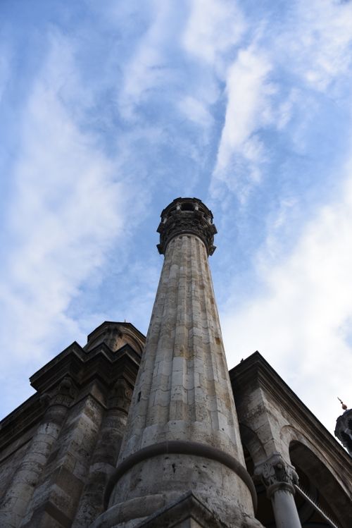 Free A stunning view of an ancient stone column and building facade against a dramatic sky. Stock Photo
