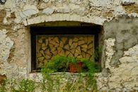A charming vintage stone window with a potted plant in rural Estonia.