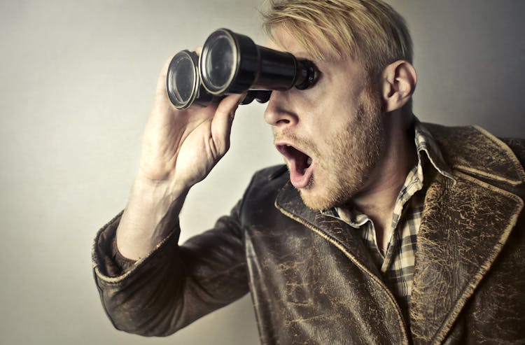 Man In Brown Leather Jacket Using Binoculars