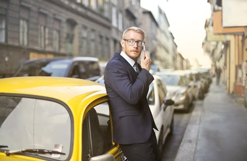 Man in Black Suit Jacket While Using Smartphone