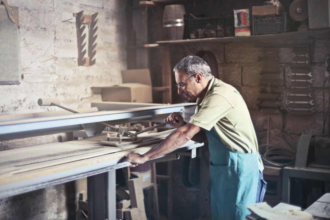 Handwerker arbeitet konzentriert an einem Werkstück – echte Arbeitssituationen sind das stärkste Motiv.