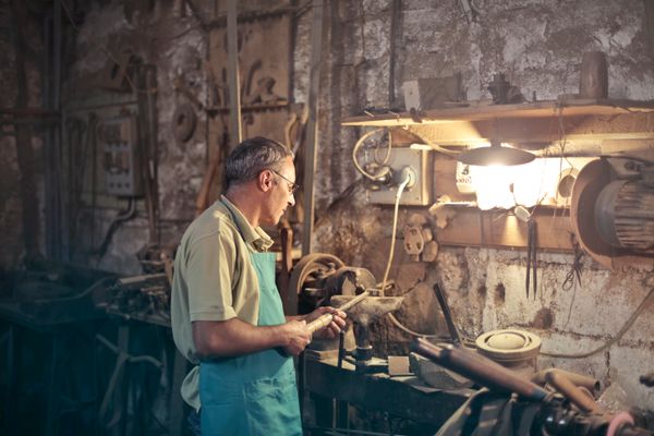 Artisan dans un atelier rustique travaillant avec ses outils