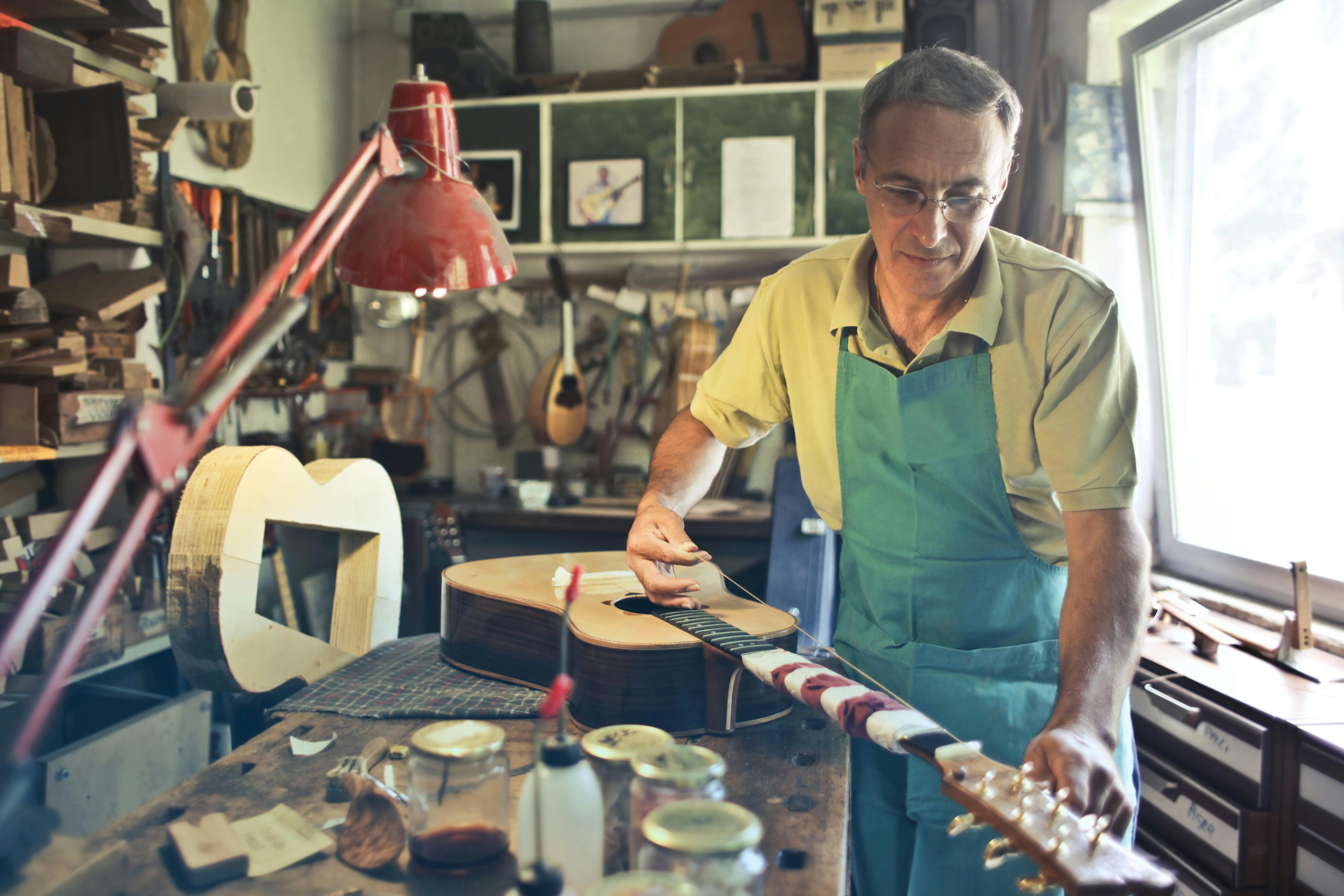 photo of man making an acoustic guitar