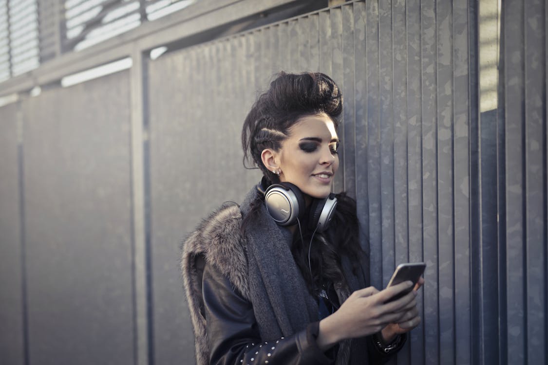 Woman in Black and Brown Fur Coat Wearing Black Headphones