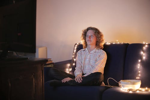 Jeune Homme Regardant La Télévision Dans Le Salon