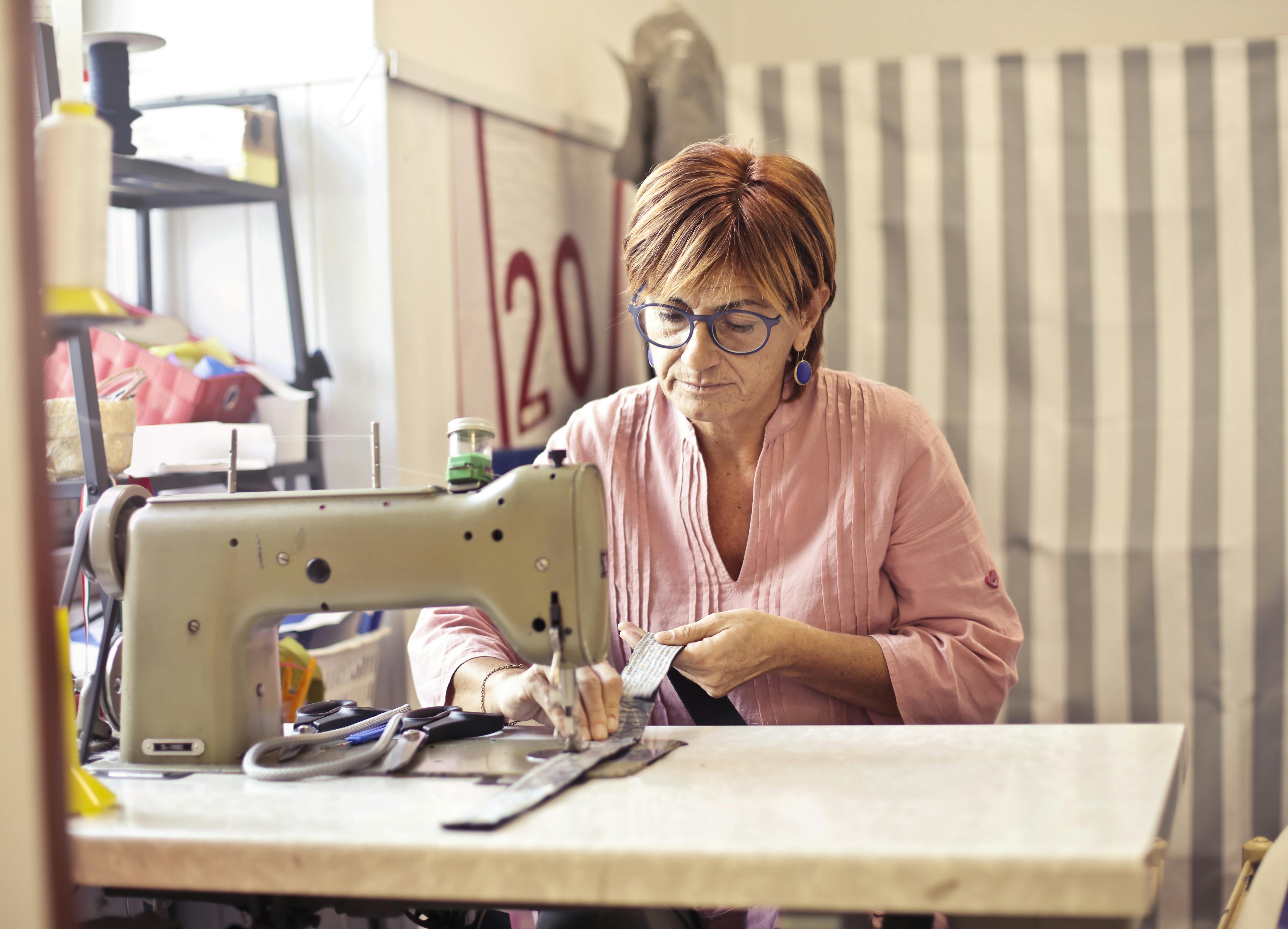 photo of woman using sewing machine