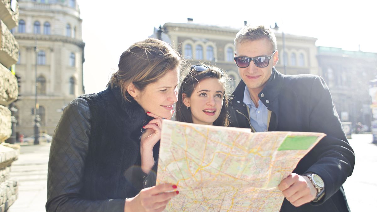 Viajeros consultando un mapa en la ciudad para pedir direcciones en inglés