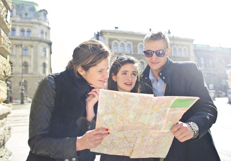 People Reading Map In The Middle Of The Street