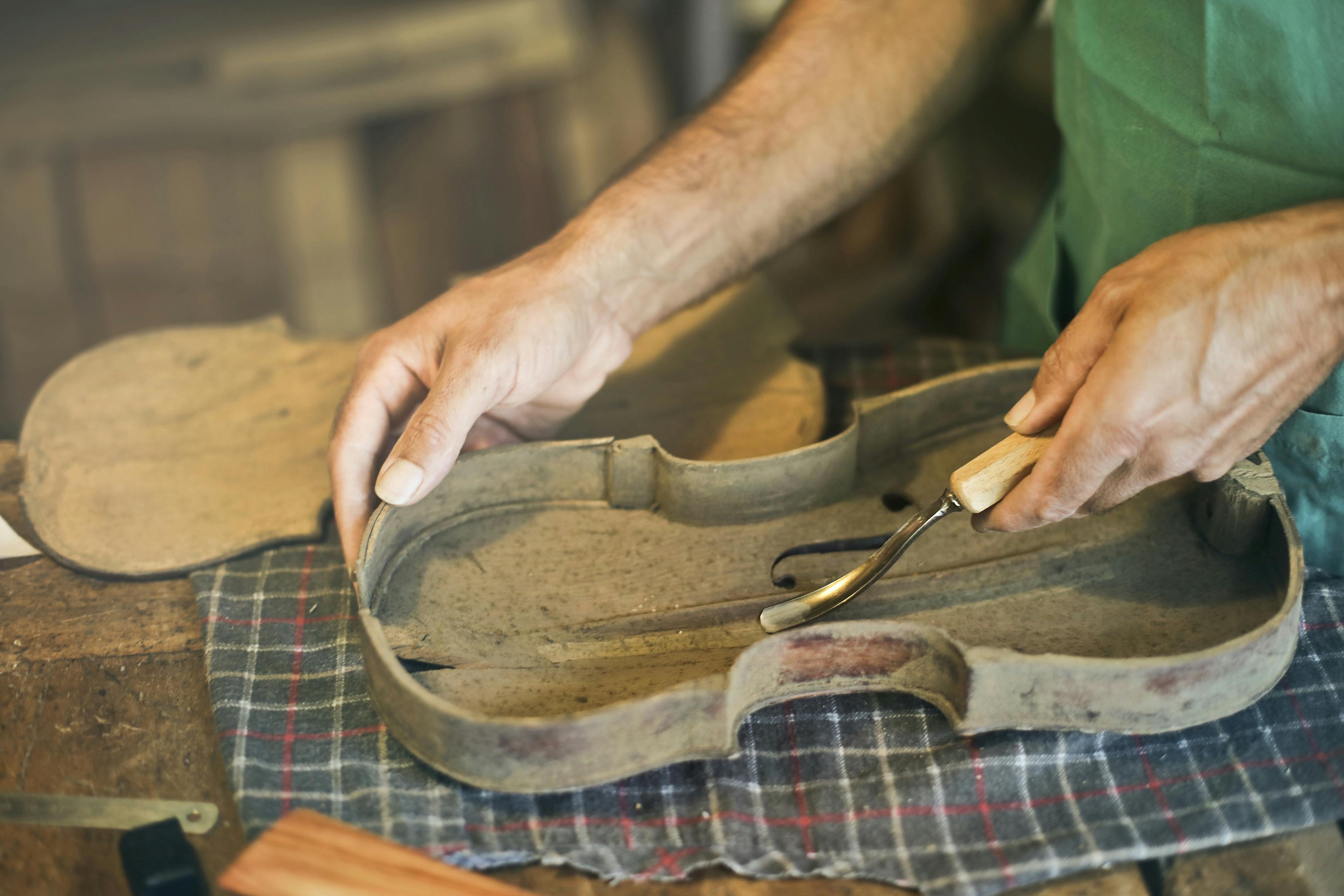 person crafting string instrument