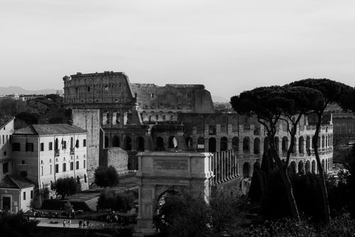 Free A dramatic black and white photo of the iconic Colosseum and surrounding Roman architecture. Stock Photo