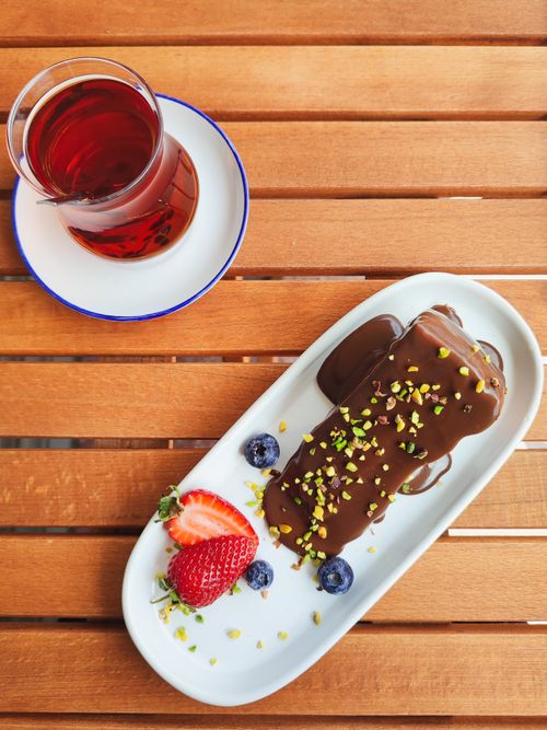 Free Chocolate dessert with strawberries, blueberries, and tea on a wooden table. Stock Photo