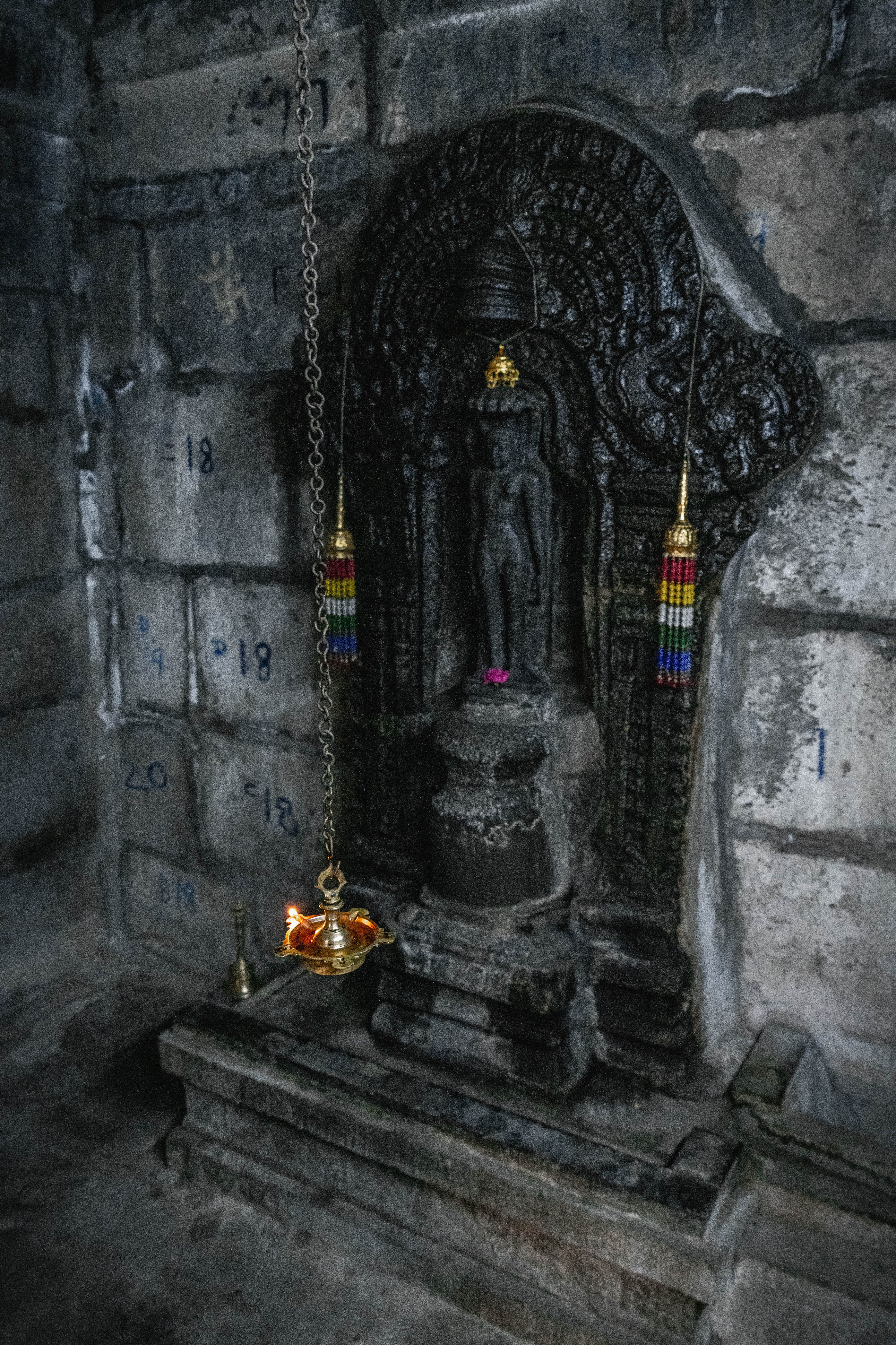 Devotees walking through a temple corridor with lamps
