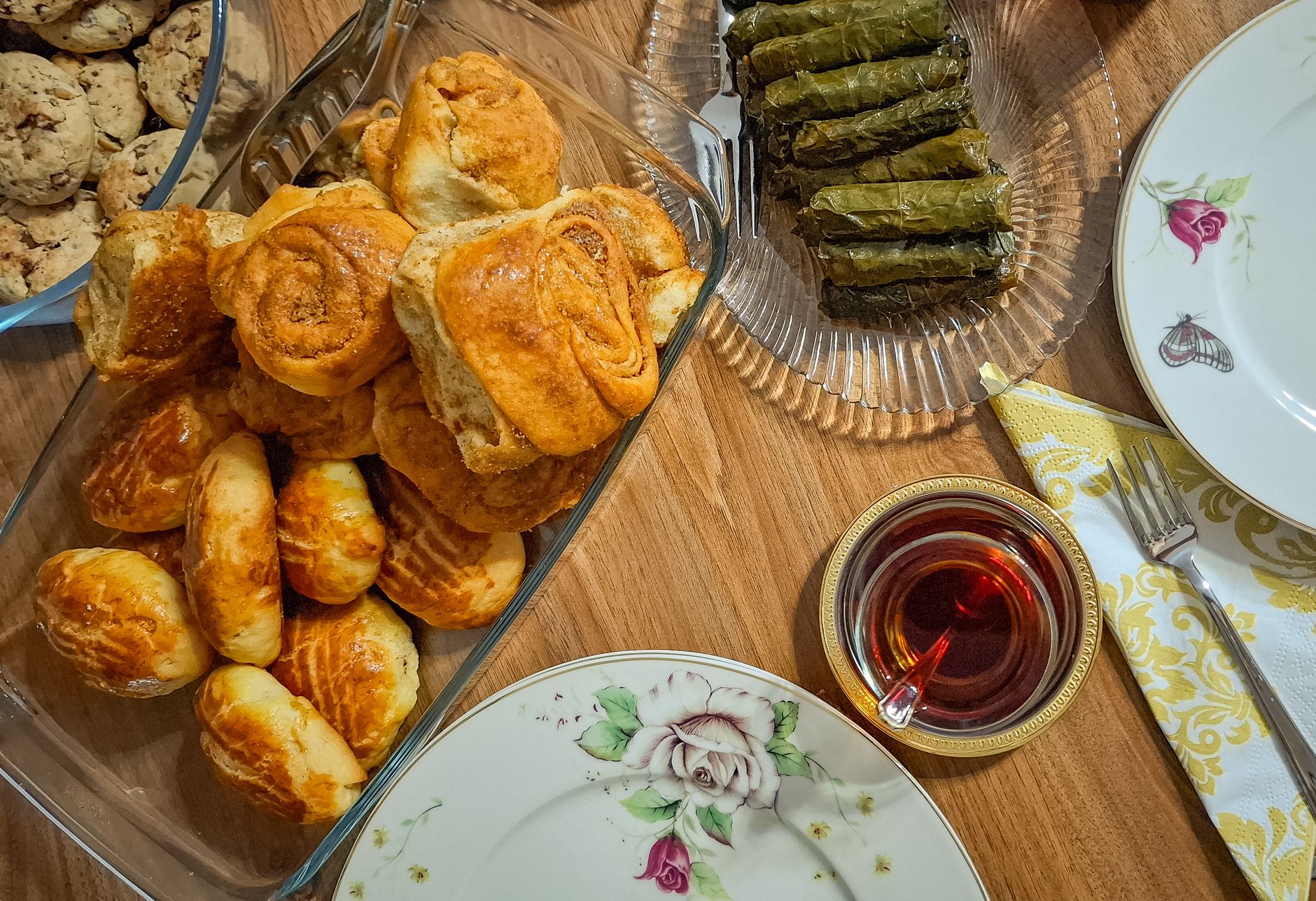 A plate of banitsa pastry with a glass of ayran on a wooden table