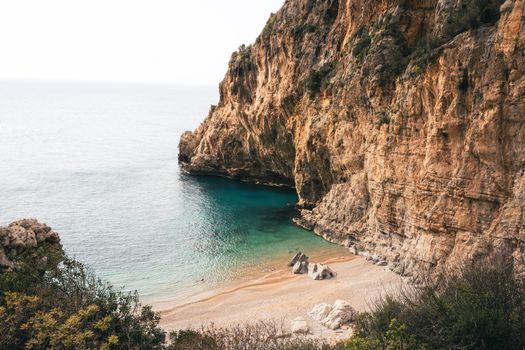 Breathtaking view of steep coastal cliffs and serene beach in Hatay, Türkiye.