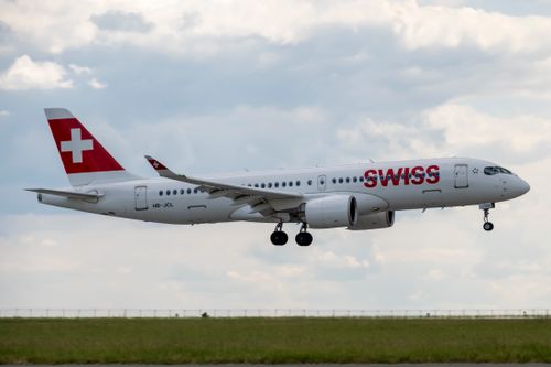 Free A Swiss airplane landing with blue sky and clouds in the background. Stock Photo