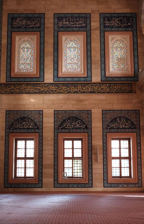Free Beautiful interior of a mosque featuring intricate Islamic designs and ornate stained glass windows. Stock Photo