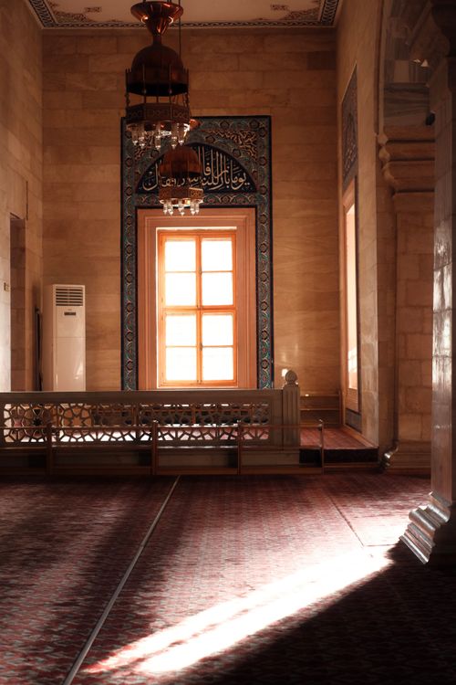 Free Sunlight streaming through a window illuminates an ornate mosque interior. Stock Photo